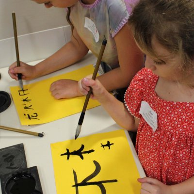 Children doing calligraphy at Explorama